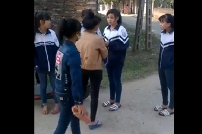 Hình ảnh một trong những nữ sinh cầm theo viên gạch uy đe dọa, uy hiếp nữ sinh khác.
