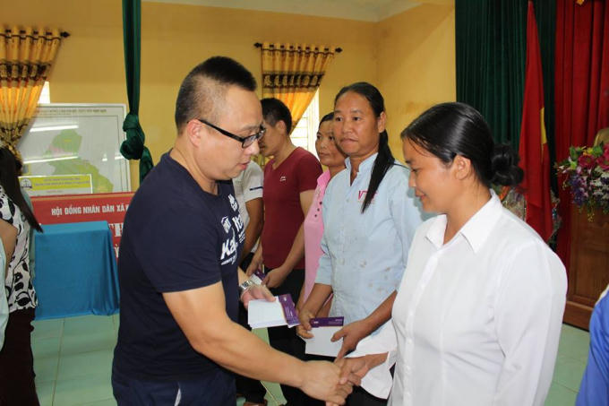 Ông Đặng Vũ Hoài, Trưởng ban bạn đọc của Báo Pháp luật Việt Nam trao quà tận tay cho các hộ dân tại xã Thạch Kiệt.
