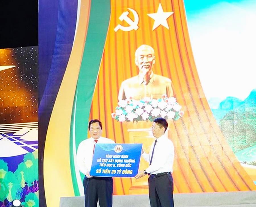 Ông Trần Song Tùng - Ủy viên BTV Tỉnh ủy, Phó Chủ tịch Thường trực UBND tỉnh Ninh Bình (bên phải) trao bảng tượng trưng hỗ trợ 20 tỷ đồng cho tỉnh Cà Mau sửa chữa một công trình trường học cho tỉnh Cà Mau (Ảnh: Báo và Phát thanh, Truyền hình Cà Mau).