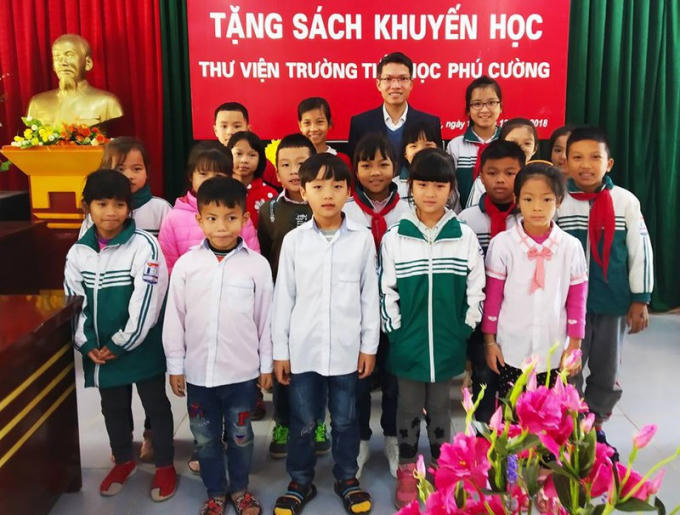 Nhà báo, nhà thơ Khúc Hồng Thiện với học sinh Trường tiểu học xã Phú Cường (TP Hưng Yên) trong buổi trao tặng sách của Thư viện Hồng Châu (12/2018)