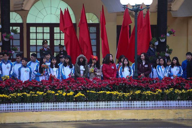 Các học sinh cầm cờ hoa chờ đón nhà lãnh đạo Triều Tiên.