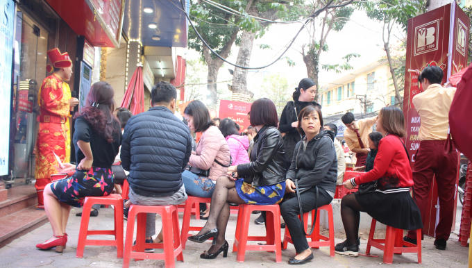 Khách hàng phải ngồi trên ghế nhựa để xếp hàng chờ tới lượt.