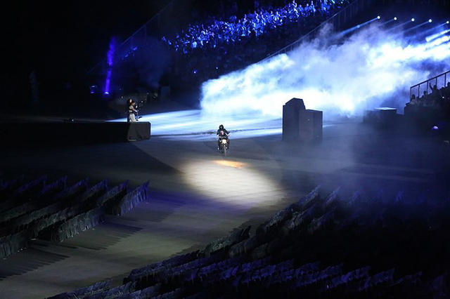 Một người cưỡi mô tô tiến vào sân vận động...