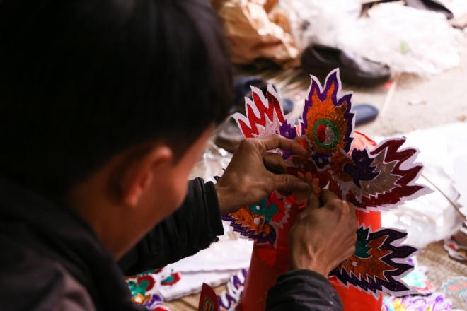 Sau khi cắt ghép các hình khối, anh Hải dùng keo dính để cố định sản phẩm.