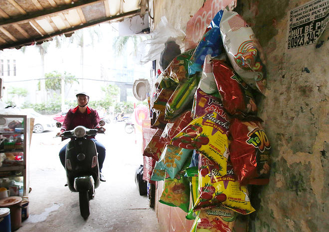 Một quán nước lùi vào ngõ ở phố Cát Linh và người dân tận dựng bức tường để treo đồ.