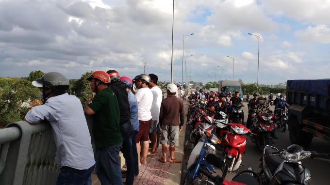 Người dân hiếu kỳ tập trung trên cầu Rạch Tra theo dõi.