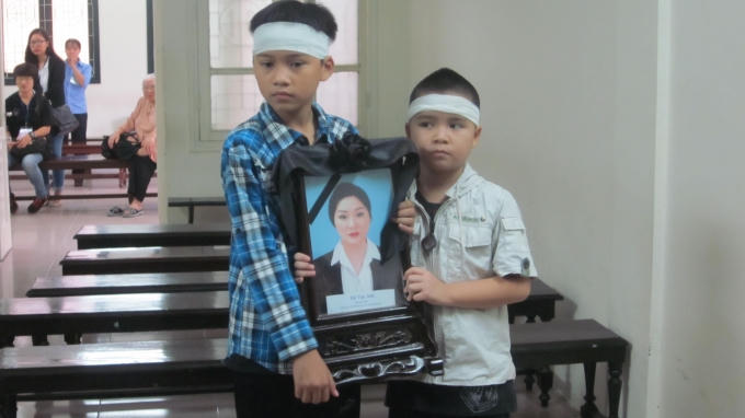 Hai đứa trẻ ngơ ngác, đầu quấn khăn tang khiến mọi người dự tòa không cầm được nước mắt (Ảnh: Duy Khương)