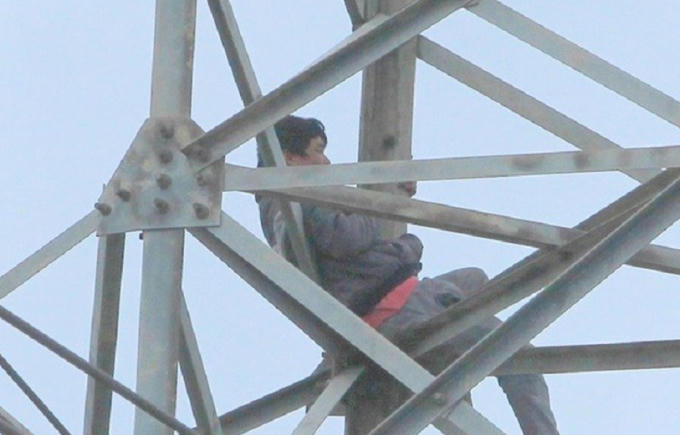 Người đàn ông nghi ngáo đá ngồi vắt vẻo trên cột điện cao thế nhiều giờ đồng hồ.