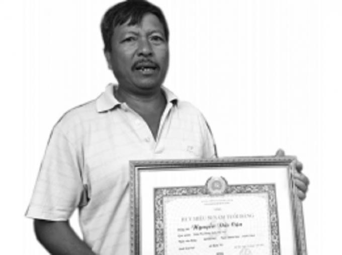 Ông Nguyễn Đức Hoàng cầm “huy hiệu 50 năm tuổi Đảng” của bố ông.