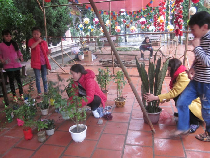 Cô trò đang trồng cây, chuẩn bị cho ngày hội chợ.