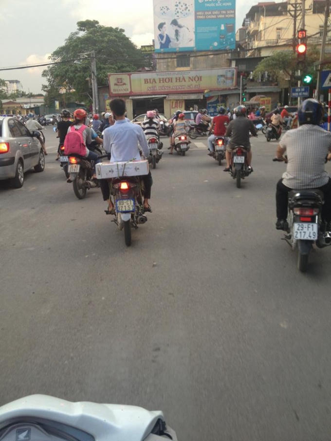 Một bạn trẻ khi tham gia giao thông không đội mũ bảo hiểm, vô tư sử dụng điện thoại khi lái xe (ảnh Thanh Huyền)