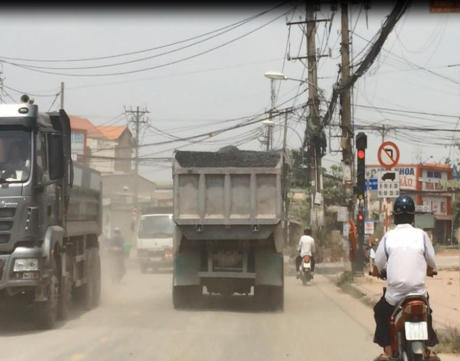 Đất, cát rơi vãi khắp đường tạo thành những "cơn bão bụi" che hết tầm nhìn người tham gia giao thông.