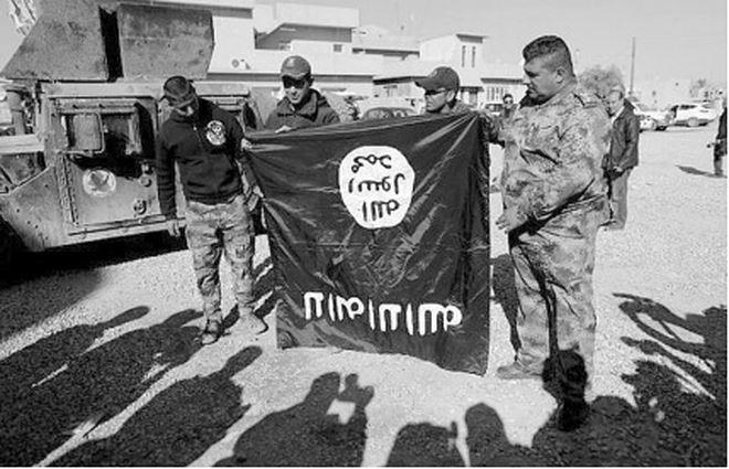 Quân đội Iraq cầm lá cờ nhóm IS ở ngoại ô Mosul.