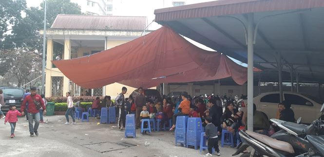 Bệnh viện căng bạt, xếp ghế nhựa cho phụ huynh và các bé ngồi chờ đến lượt vào khám