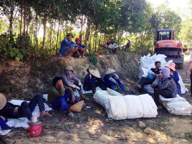 Các công nhân tranh thủ nghỉ ngơi sau 2 ngày liên tục bốc dỡ, di dời gần 300 tấn chất thải lẫn đất.