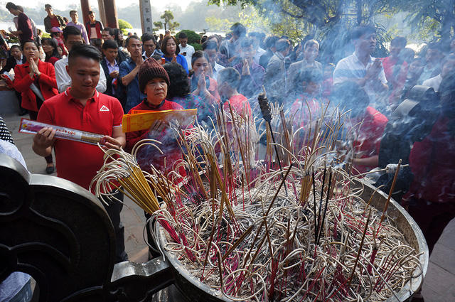 Đền Ngọc Sơn (Hà Nội) mở cửa từ 7 giờ sáng đến 18 giờ hàng ngày. Tuy nhiên, lượng người tập trung đông nhất trong khoảng từ 10h đến 16h. Hàng nghìn lượt khách “gói gọn” trong giờ vàng đã tạo ra cảnh đông đúc, chen lấn đến nghẹt thở. Trong ảnh là cảnh hàng đoàn người chen nhau chật cứng tại lối dẫn vào cổng đền.