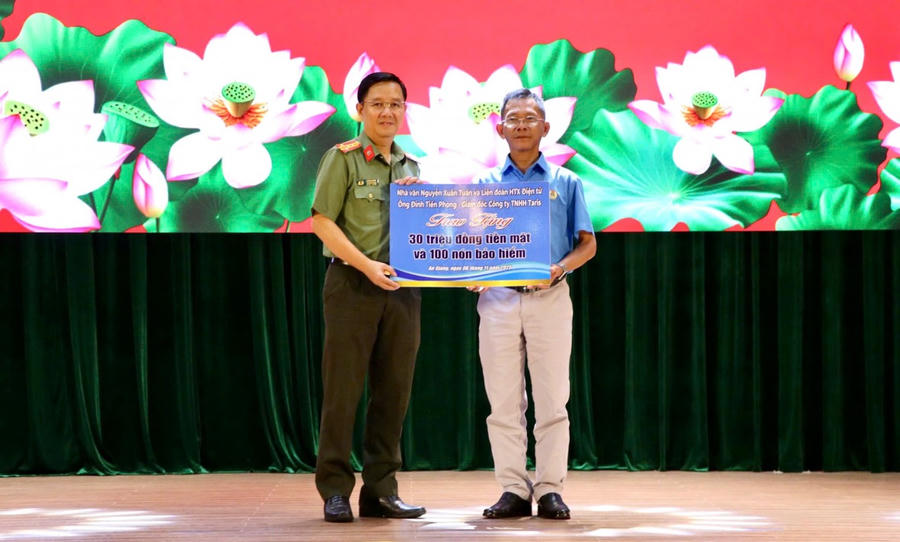 Đồng chí Đại tá Lê Phú Thạnh, Phó Giám đốc Công an tỉnh tiếp nhận bảng tượng trưng số tiền mạnh thường quân hỗ trợ các hộ dân bị thiệt hại do sạt lở