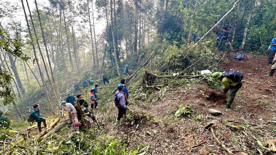 Lực lượng chức năng và người dân cắt đường băng cản lửa. (Ảnh: Báo Hà Giang)