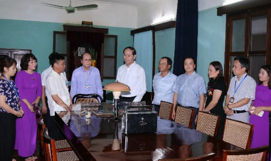 Chủ tịch nước Trần Đại Quang, Chủ nhiệm Văn phòng Chủ tịch nước Đào Việt Trung và cán bộ, nhân viên Khu di tích Chủ tịch Hồ Chí Minh bên nhà sàn Bác Hồ.