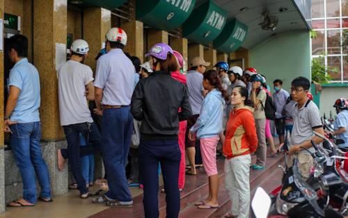 Tại các khu công nghiệp Linh Xuân (quận Thủ Đức), khu chế xuất Tân Thuận (quận 7), hàng trăm công nhân xếp hàng dài trước trụ ATM để tút tiền về Tết.