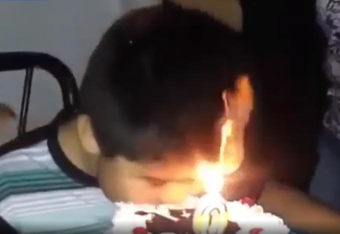 Cậu b&eacute; thưởng thức miếng b&aacute;nh sinh nhật đầu ti&ecirc;n ch&aacute;y cả t&oacute;c. Ảnh: Cắt từ clip