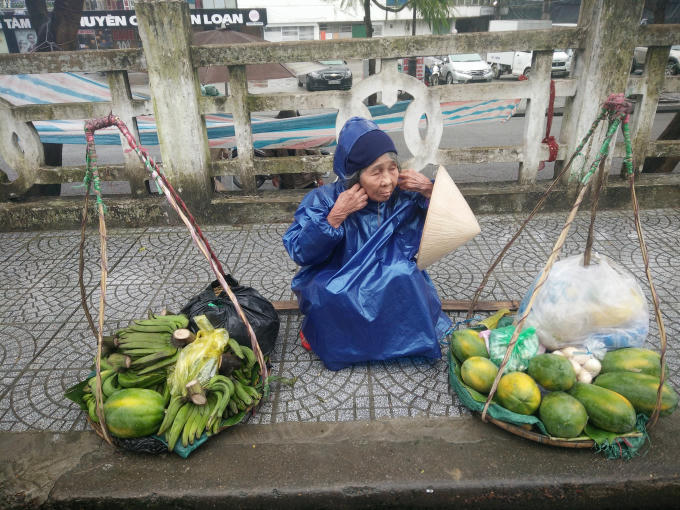 Cầu Tràng Tiền, cụ bà bán hàng chống chọi với giá lạnh. (Ảnh: Như Quỳnh)