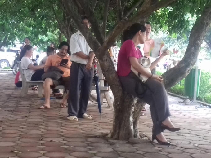 Các phụ huynh tránh nắng bằng nhiều tư thế.