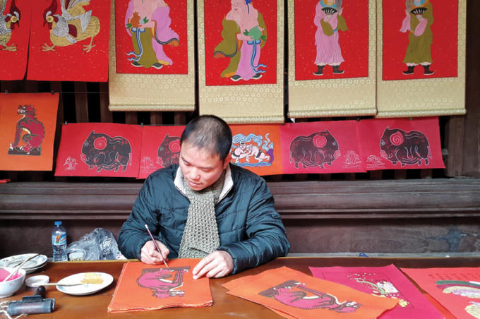 Nhiều năm qua, anh Đào Đình Trung, xã Vân Canh, Hoài Đức, Hà Nội, luôn tâm huyết phục hồi dòng tranh Kim Hoàng. Ảnh: Đinh Thuận/TTXVN.