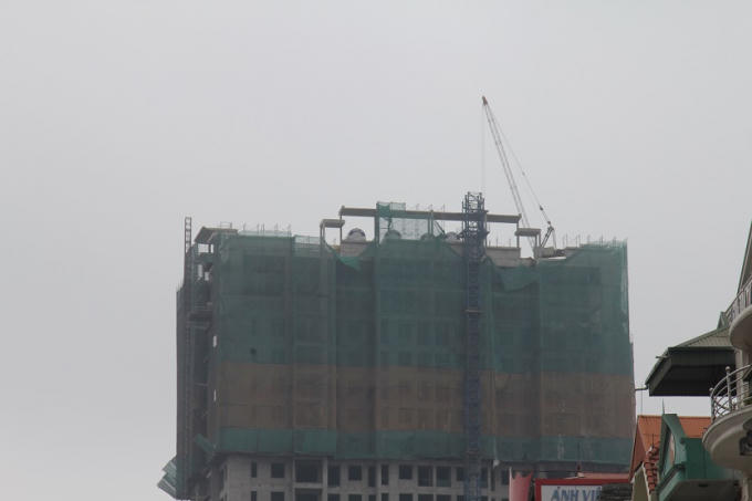 Một cần cẩu được đưa lên đỉnh tòa nhà phục vụ công tác tháo dỡ cẩu tháp bị gãy.