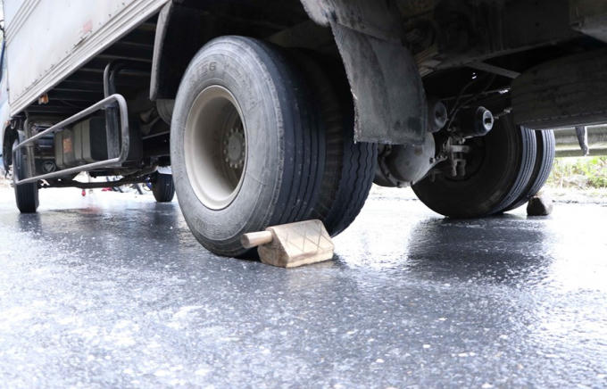 Các chủ xe phải chèn bánh để chống trượt. (Ảnh: Nguyễn Oanh/TTXVN)