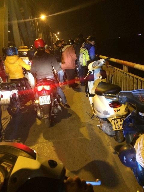 Rất đông người dân hiếu kì đứng lại bên thành cầu để xem cứu hộ nạn nhân.