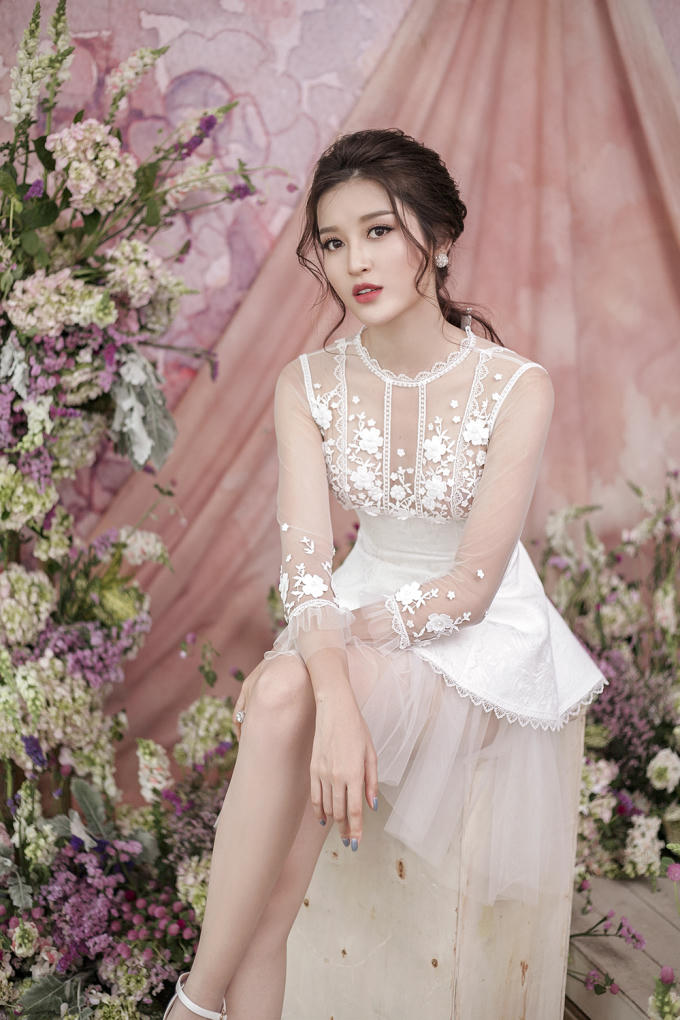 Chiếc váy thứ tư có sự khác biệt với chất liệu gấm được thiết kế theo dạng vạt xéo hiện đại. Hoạ tiết hoa tiếp tục được khai thác tối đa nhưng lần này phân bổ theo chiều dọc thân trước váy mang lại hiệu ứng bắt mắt.