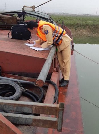 Phòng cảnh sát đường thủy (PC 68) công an tỉnh Hà Tĩnh đang lập biên bản sà lan "cát tặc" của Phạm Văn Chuyên.