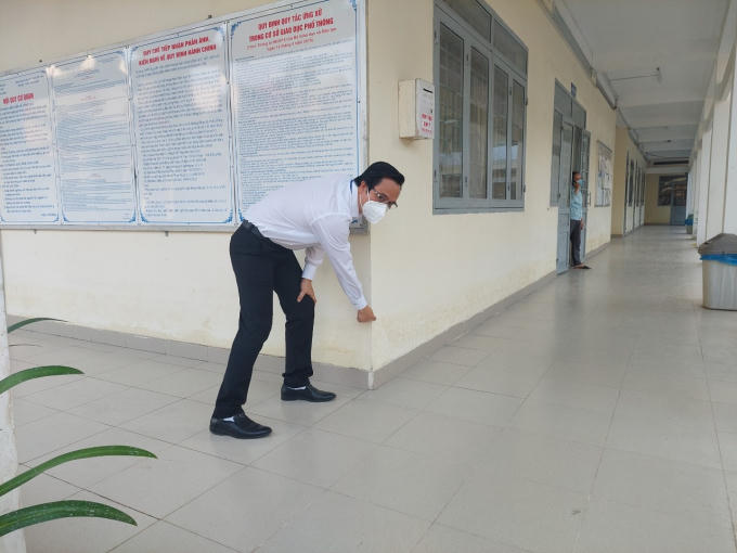 Thầy Phan Anh Tuyến chỉ vào dấu vạch nước ngập còn in lại trên tường.