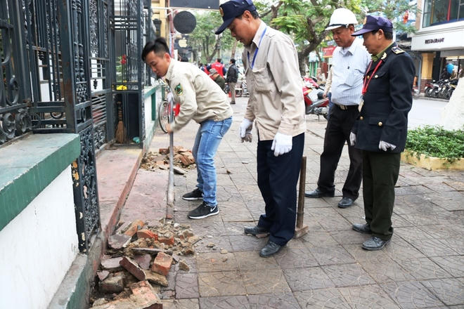 Sau khi dùng xà beng tháo dỡ các hạng mục vi phạm, nhà chức trách chuyển gạch vỡ lên xe tải đưa đi nơi khác.