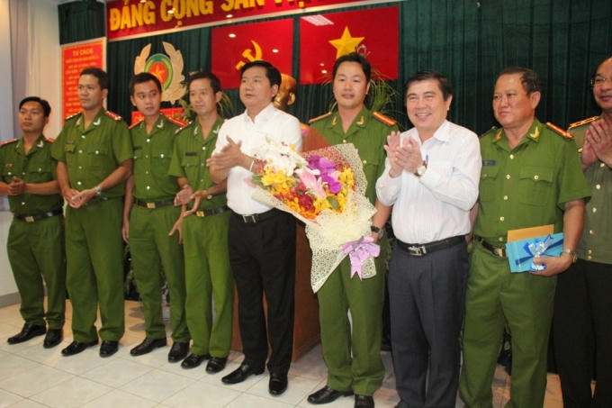 Bí thư Thành ủy Đinh La Thăng và Chủ tịch UBND TP HCM Nguyễn Thành Phong khen thưởng, khích lệ tinh thần Công an quận 1. (Ảnh: PLO)