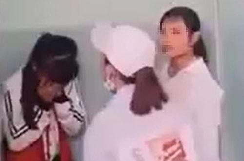 Nữ sinh lớp 7 (trái) bị vây đánh trong nhà vệ sinh ở Phú Yên, hôm 15/3. Ảnh:Cắt từ video.