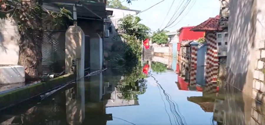 Người dân phải lội nước đi trong đường làng ngõ xóm.