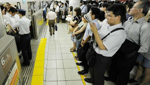 Người dân đứng xếp hàng tại một ga tàu điện ngầm ở Tokyo, Nhật Bản.