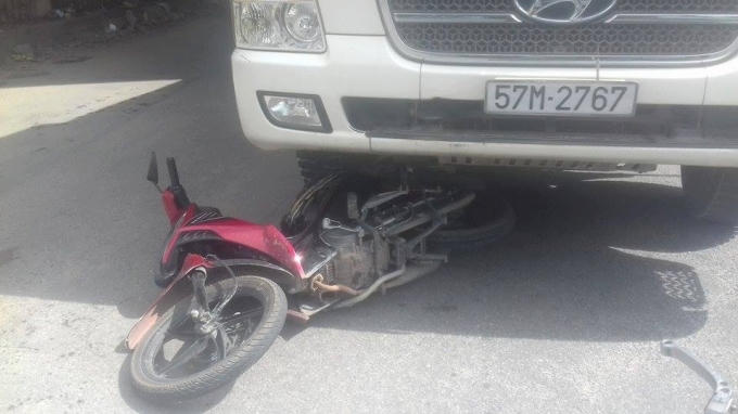 Chiếc xe máy nằm dưới gầm xe ben.