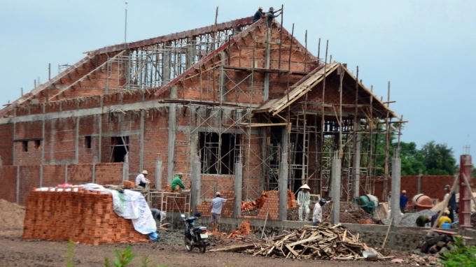 Ngoài thợ hồ còn có phạm nhân trong trang phục sọc trắng - xanh cùng xây dựng nhà đại tá Thắng - Ảnh: Đ.TR.