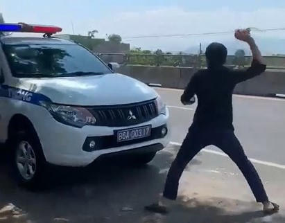 Nhặt thanh long bên đường ném liên tiếp vào xe cảnh sát giao thông.