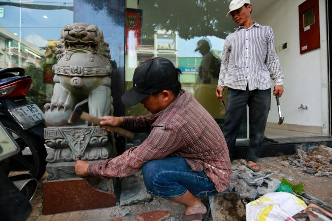 Một cửa hàng gần đó cũng thuê hai công nhân "bứng" chú sư tử đá để trả lại vỉa hè cho người đi bộ.