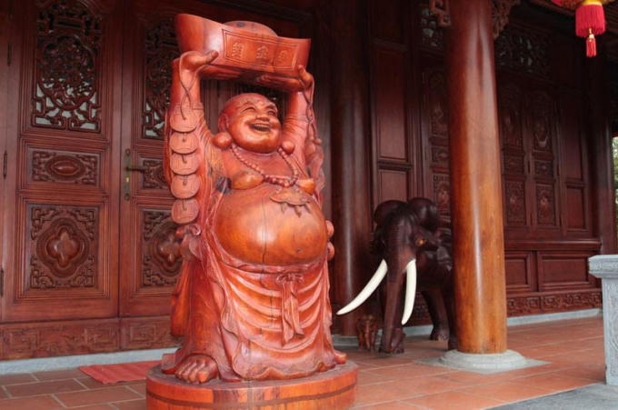 Hai bên cánh cửa ra vào nhà chính có voi chầu và tượng Phật Di lặc.