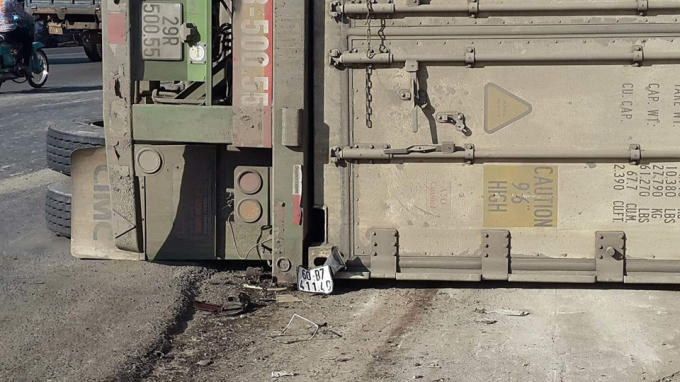 Chiếc xe máy biến dạng nằm dưới thùng xe container.