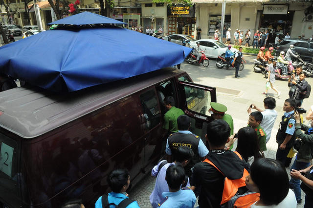 Đưa người bị bắt vào trong xe. Ảnh: Đình Thảo