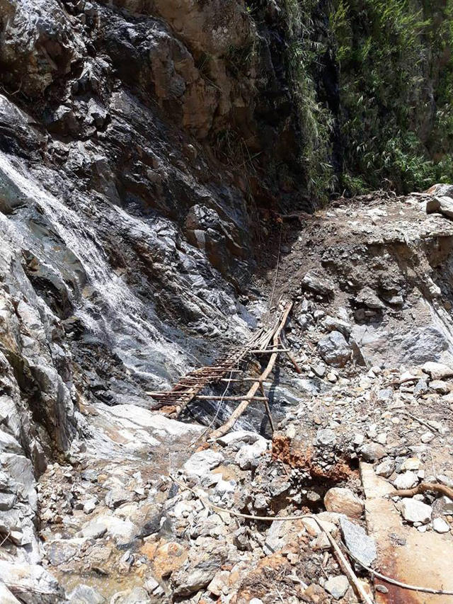 Một đoạn đường bị sạt lở phải bắc cầu tạm là những thanh gỗ, cây rừng để băng qua.