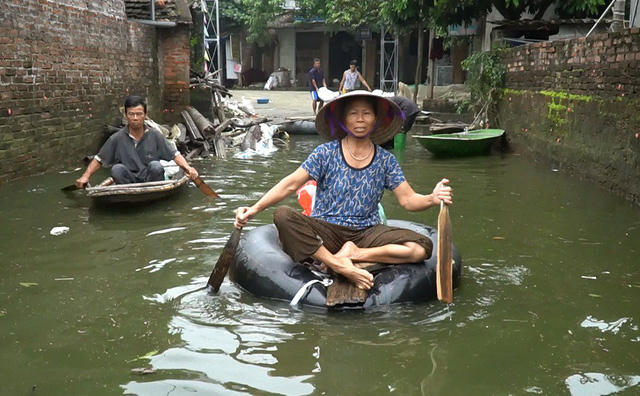 Hơn nửa tháng trôi qua, làng Nam Hài (xã Nam Phương Tiến, Quốc Oai) vẫn ngập chìm trong nước. Nhiều người dân chèo thuyền đi nhận quà từ thiện.