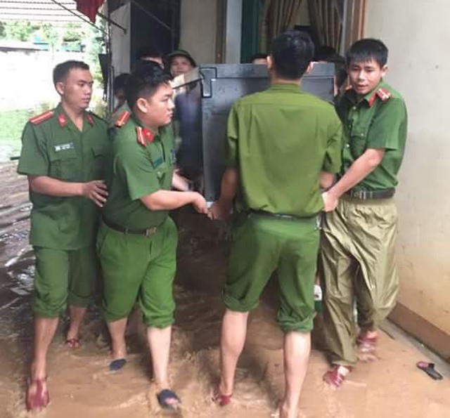 C&ocirc;ng an, bộ đội dầm m&igrave;nh trong nước lũ đục ngầu gi&uacute;p d&acirc;n