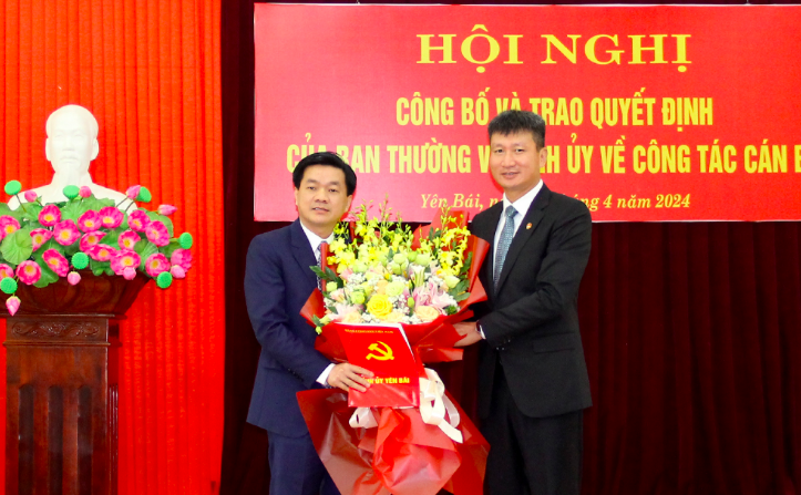 Ông Trần Huy Tuấn - Phó Bí thư Tỉnh ủy, Chủ tịch UBND tỉnh Yên Bái trao Quyết định và tặng hoa chúc mừng tân Phó Trưởng Ban Nội chính Tỉnh ủy.